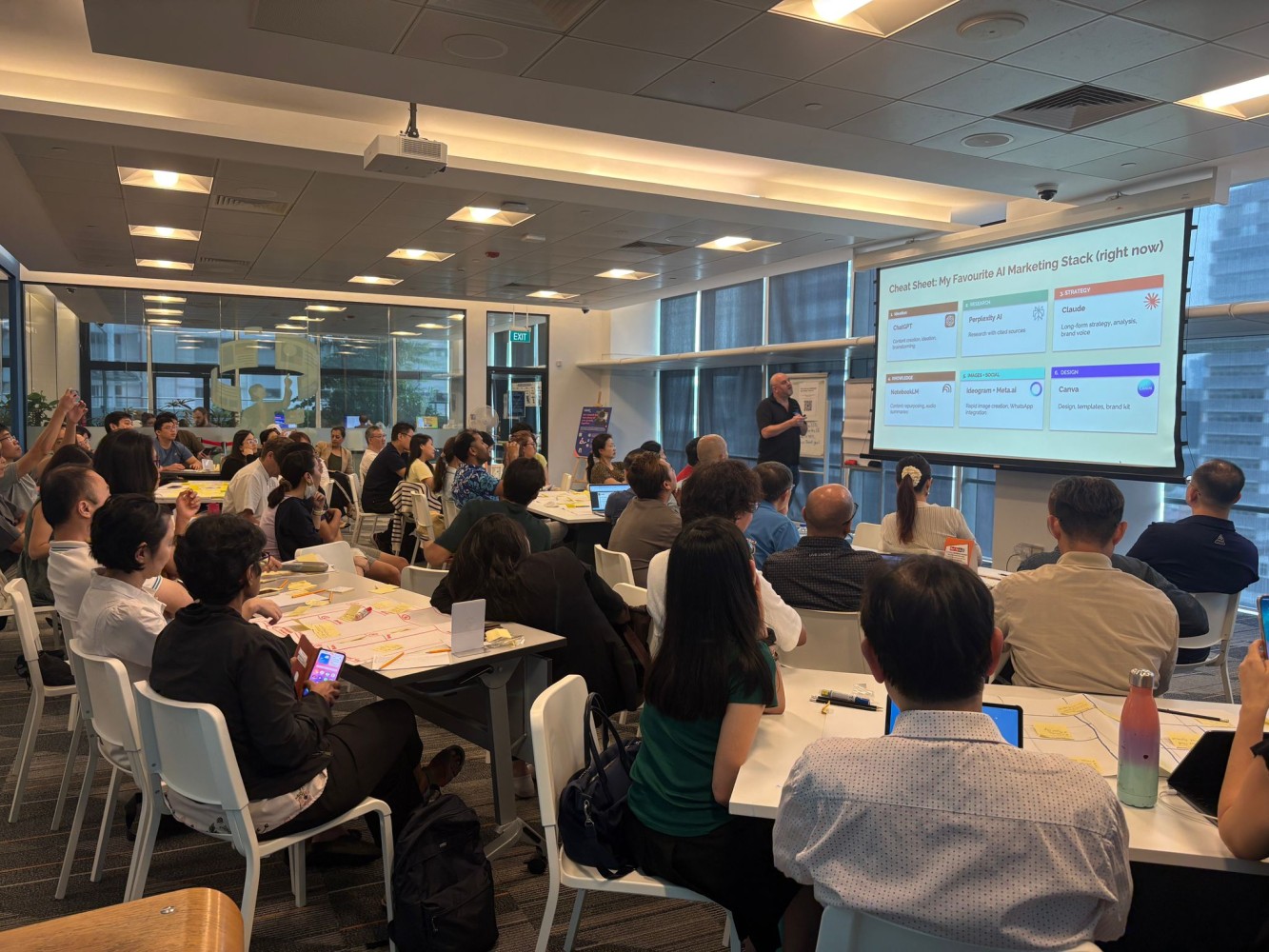 Adrian Watkins running a workshop session for founders. Workshop agenda on the screen, a full room of attendees seated and engaged.